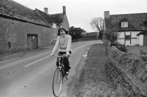 00702 Prints: Pam Ayres riding her bicycle near her home in a village in Oxfordshire. 12th May 1977