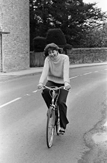 00702 Prints: Pam Ayres riding her bicycle near her home in a village in Oxfordshire. 12th May 1977