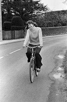 00702 Prints: Pam Ayres riding her bicycle near her home in a village in Oxfordshire. 12th May 1977
