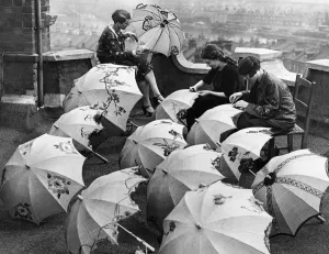 Parasol Novelties. The latest raffin summer parasol seen here being decorated by artist