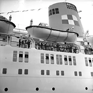 Liner Prints: Passengers wave as they stand underneath the lifeboats on the deck of the Empress of