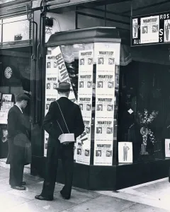 Gas Masks Prints: A passer-by look at a tailor shop window plastered with copies of the Daily Mirror Hitler