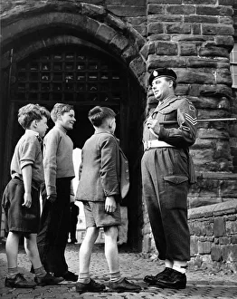 Baton Prints: This patient sergeant answers the many questions of these young lads at the gate of