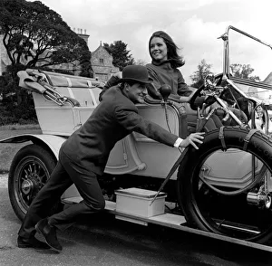 Patrick Macnee & Diana Rigg stars of The Avengers pushing a vintage car on set