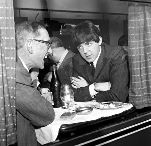 Paul McCartney of The Beatles and actor Wilfred Bramble chat at dining table