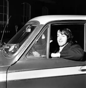 Paul McCartney of the Beatles leaves by car driven by Peter Asher from the Apple