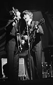 Paul McCartney and George Harrison of The Beatles performing on stage in Carlisle