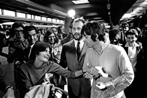 Paul McCartney has his hand held by a fan as The Beatles leave London Euston Station for