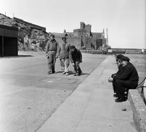 Coastal Prints: Peel Castle on St Patricks Isle, Isle of Man serves as a background to a Jeu de Boule