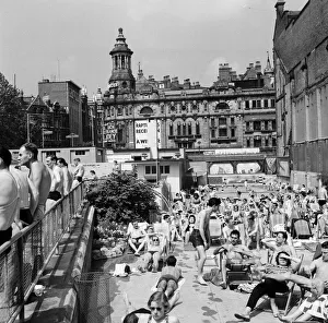 Swimsuit Prints: People enjoying the warm weather at Endell Street open air baths, London. 5th August 1954