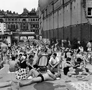 People enjoying the warm weather at Endell Street open air baths, London. 5th August 1954