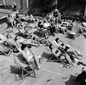 People enjoying the warm weather at Endell Street open air baths, London. 5th August 1954
