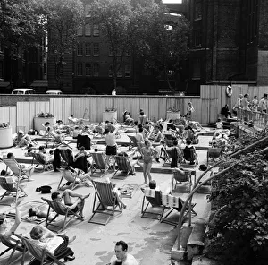 People enjoying the warm weather at Endell Street open air baths, London. 5th August 1954