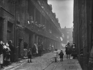 People standing between two terraces in a slum housing area of Liverpool. 2nd March, 1933