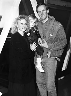Peter Davison actor with his wife Sandra Dickenson and baby Georgia at Heathrow before