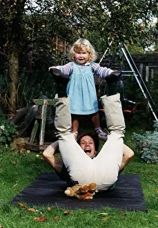 Peter Duncan TV presenter of Blue Peter playing in the garden with his daughter