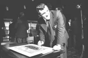 Phil Bennett signing the visitors book at the International Sports Writers Club in Great