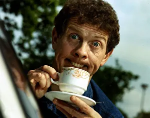 Phil Cool Comic pulling funny face holding cup and saucer Dbase