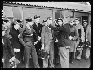 Equipment Prints: A photograph of a group of Bevin Boy miners receiving their equipment on their