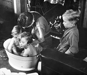 Picture shows a boy scout bathing a baby. Newcastle. Tyne and Wear