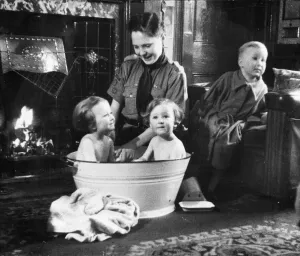 Picture shows a boy scout bathing a baby. Newcastle. Tyne and Wear
