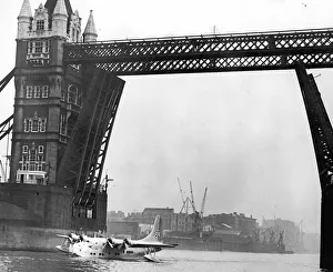 Picture shows the first flying boat on the Thames for 21 years-passing under Tower Bridge