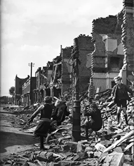Ruins Prints: Picture shows young boys playing in the ruins of housing decimated in the Blitz of