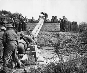 The Pioneer Corps handling tins and drums of petrol and oil using a human chain