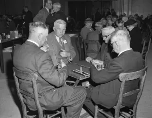 Players playing their dominoes close to their chests, at the Over Sixties