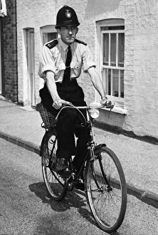 Officer Prints: A police officer doing his rounds on a bicycle in Cambridgeshire. July 1964
