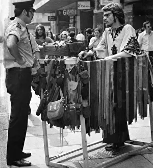Police have a word with a street trader selling leather goods on Oxford Street