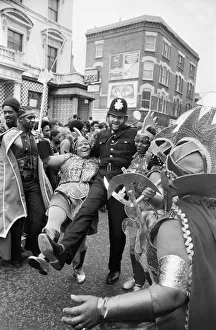 Trident Prints: A policeman dances with a woman in costume at Notting Hill carnival