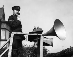 Policeman with a loudspeaker trying to control the crowds at the Grand National