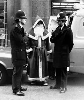 Presents Prints: Policemen speak to Santa Claus outise Harrods Store in London after being nicked for