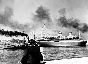 The Polish Liner Batory is watched by a father and daughter as she is gently manoeuvred
