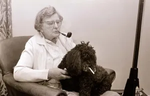 The Poodle who eats cigarettes An old lady smoking a pipe with her pet poodle who