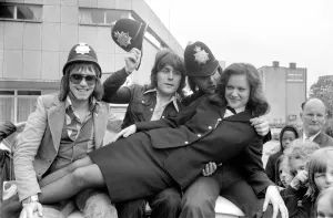 Pop Group Mud'. with police officer as they wear pilce helmets May 1975