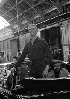 Pop singer David Bowie smiles as he arrives at Victoria Station in London May 1976