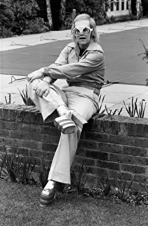 Pop singer Elton John at his home at Virginia Water wearing his latest boots