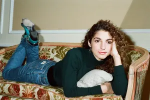 Pop singer Gloria Estefan poses lying down on a sofa in her hotel room on a visit to