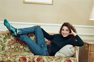 Jeans Prints: Pop singer Gloria Estefan poses lying down on a sofa in her hotel room on a visit to