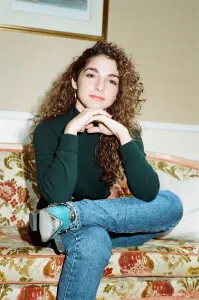 Pop singer Gloria Estefan poses sitting down on a sofa in her hotel room on a visit to