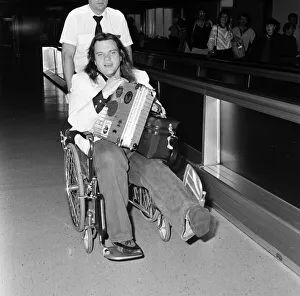 00962 Prints: Pop singer Meat Loaf leaving Heathrow Airport in a wheelchair. 23rd June 1985