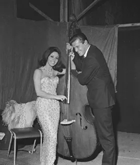 Instrument Prints: Pop singer Susan Maughan and actor Roger Moore photographed with a cello backstage during
