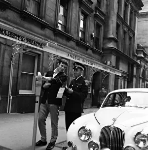 Pop star Marty Wilde, 22, is given a parking ticket after parking his cream Jaguar