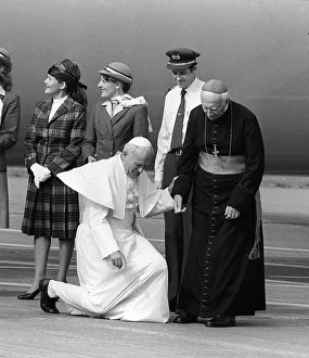 Pope John Paul II at Cardiff airport on his visit to Wales kneels down to kiss the ground