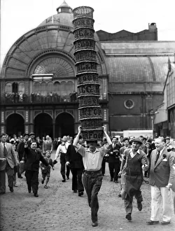 Porters from Covent Garden Flower and Vegetable market race with baskets stacked on their