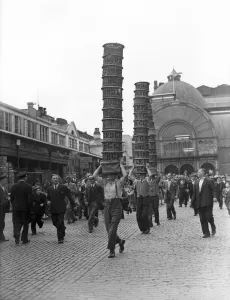 00966 Prints: Porters from Covent Garden Flower and Vegetable market race with baskets stacked on their