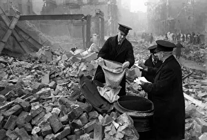 00110 Prints: Postmen shift through the wreckage of their central London sorting office looking for