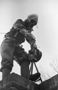 Gas Masks Prints: Preparations for war. ARP warden operates the air raid siren during a civil defence gas